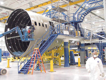 A Vought mechanic installs a beam assembly in the aft fuselage section 47 of the 787 Dreamliner.